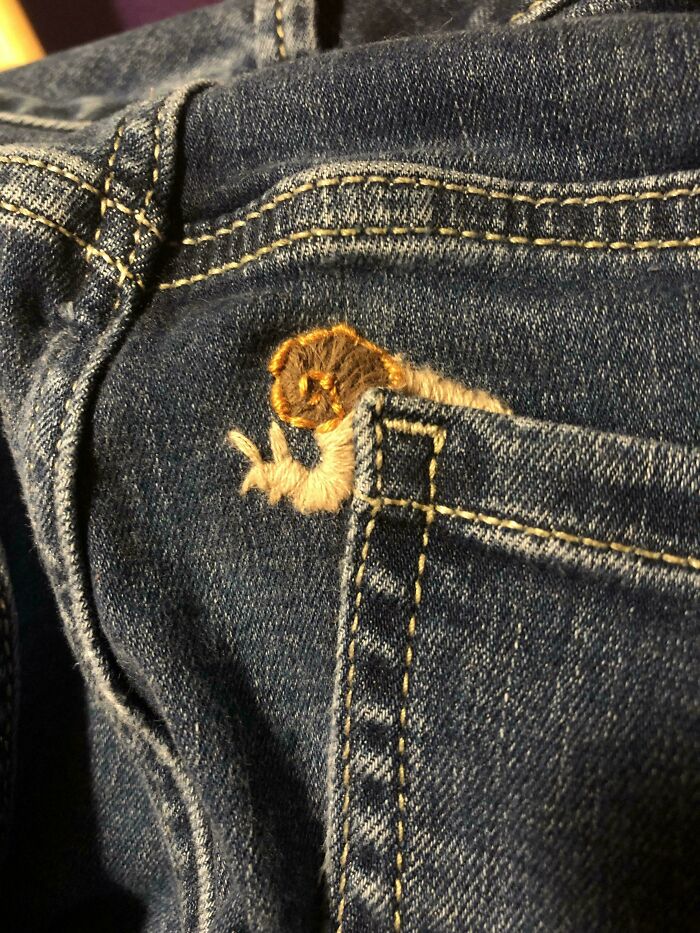 Visible mended jeans pocket with creative embroidery of a snail stitching detail making it uniquely cooler and stylish.