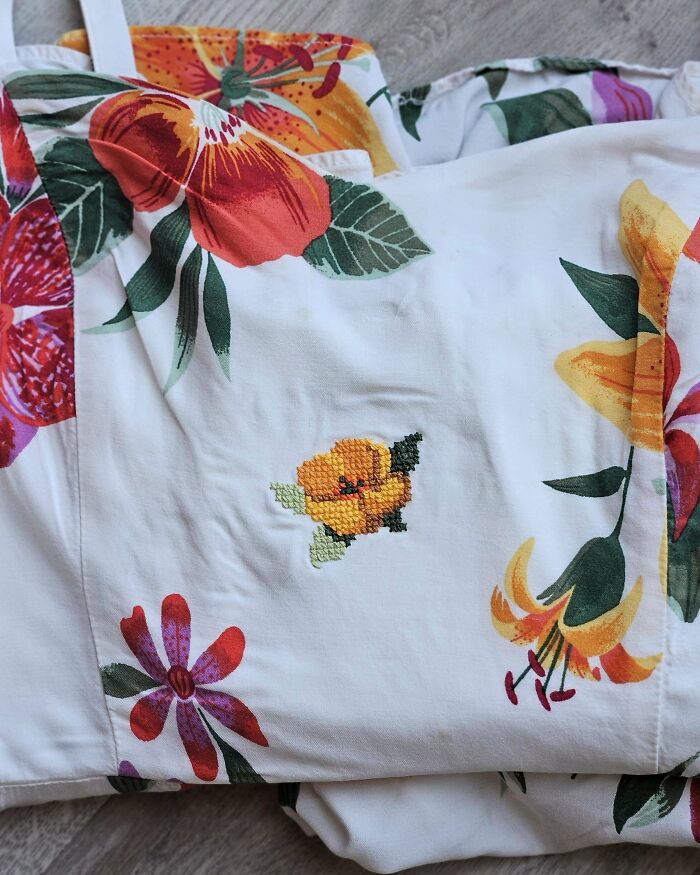 Floral fabric with visible mended flower embroidery patch, showing repaired clothing made cooler with creative visible mending.