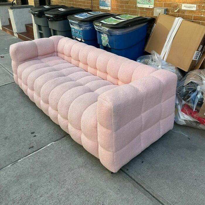 Pink tufted sofa left on NYC curb, perfect for treasure hunting.