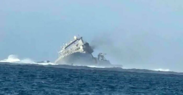 Ship tilting and emitting smoke in the ocean, portraying an unfortunate incident and likely expensive damage.