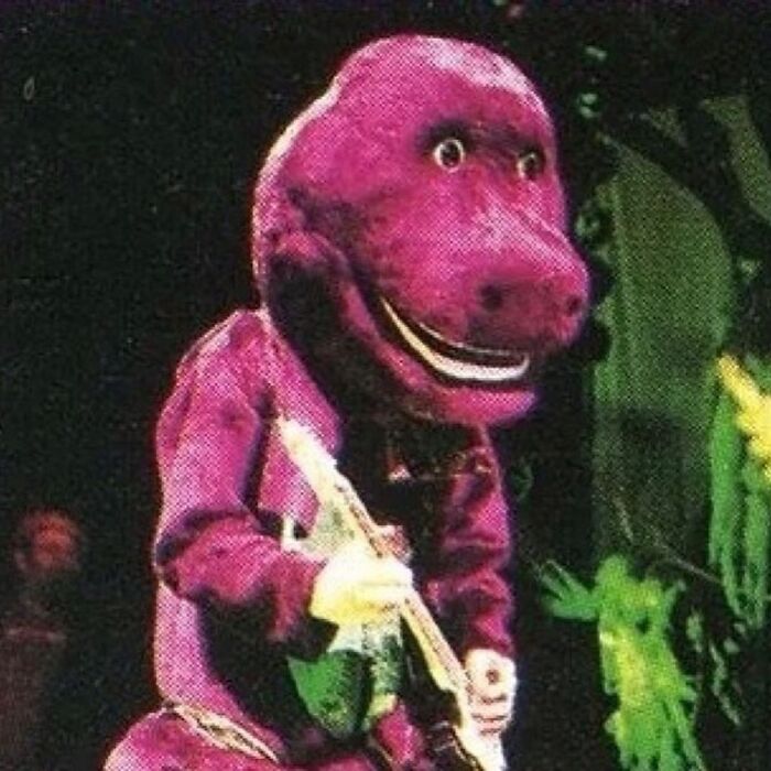 Purple dinosaur mascot joyfully playing guitar, capturing a wild ‘90s moment.