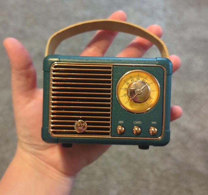 Hand holding a vintage-style small radio with gold accents, a budget-friendly find that fakes a fancy look.
