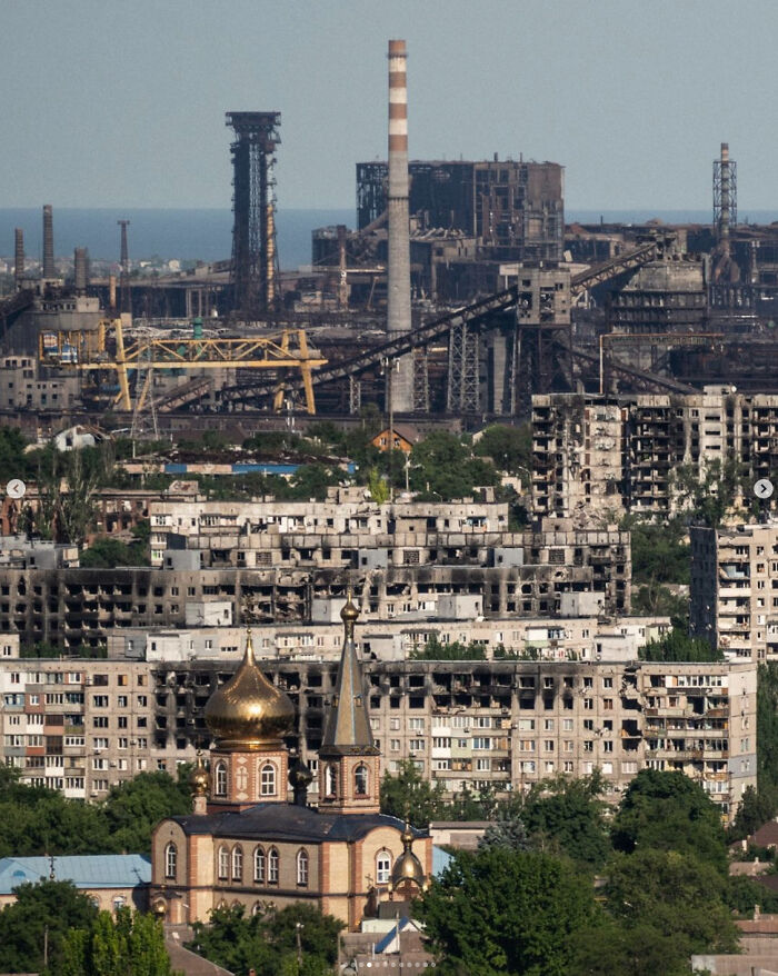 Urban decay with industrial structures and a church in front, highlighting an urban hell scenario.