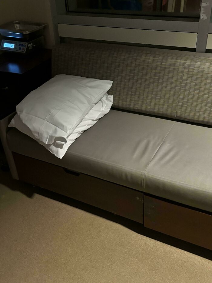 Couch turned into a makeshift bed with stacked pillows, showcasing a wholesome and funny dad's creative effort.