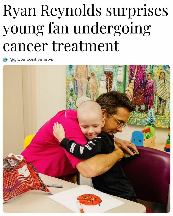 A man in a pink shirt hugs a smiling child undergoing cancer treatment in a colorful room, embodying faith in humanity.
