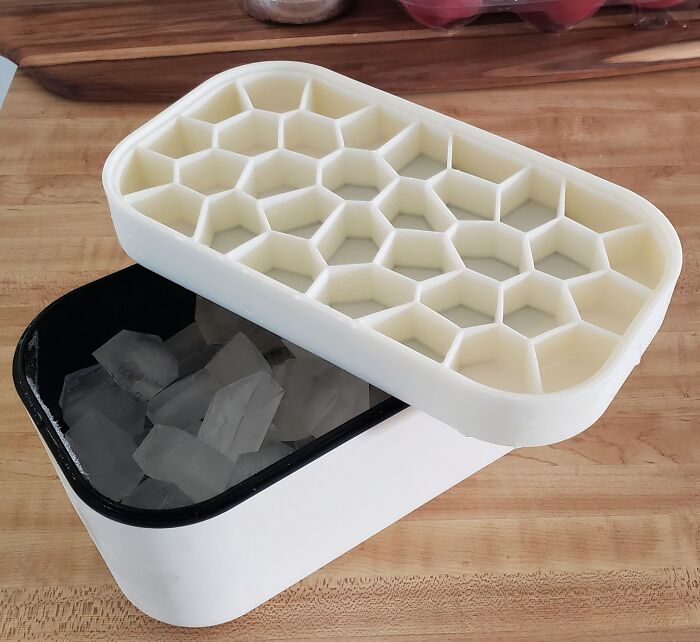 Honeycomb-shaped ice mold kitchen tool with matching container on a wooden countertop, showcasing kitchen logic.