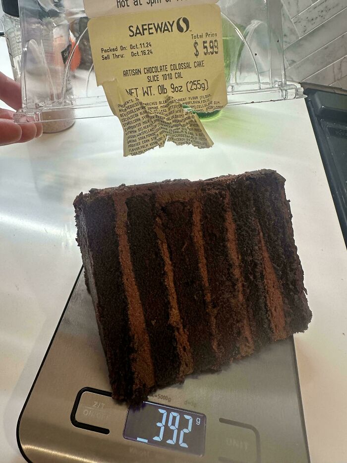 Artisan chocolate cake slice weighed on scale, showing customer request compliance in food service.