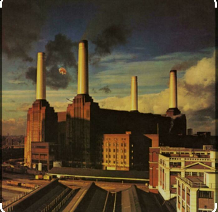 Dark industrial building with tall smokestacks emitting smoke, exuding evil aura like a supervillain headquarters.