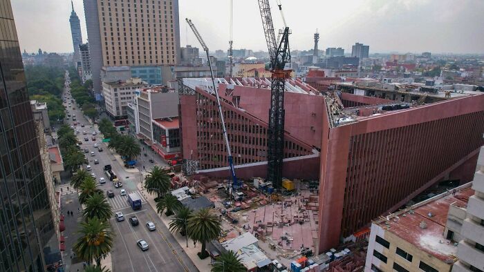 Aerial view of an urban construction site with a large building having an eerie design fitting supervillain headquarters.