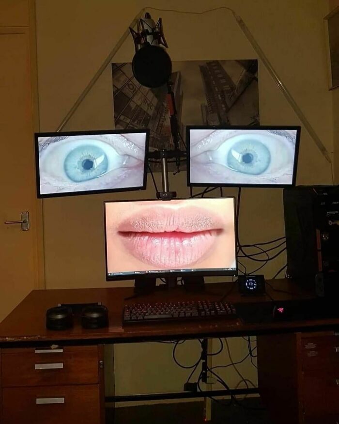 Weirdness on display: A computer setup with screens showing large eyes and lips in a peculiar arrangement.