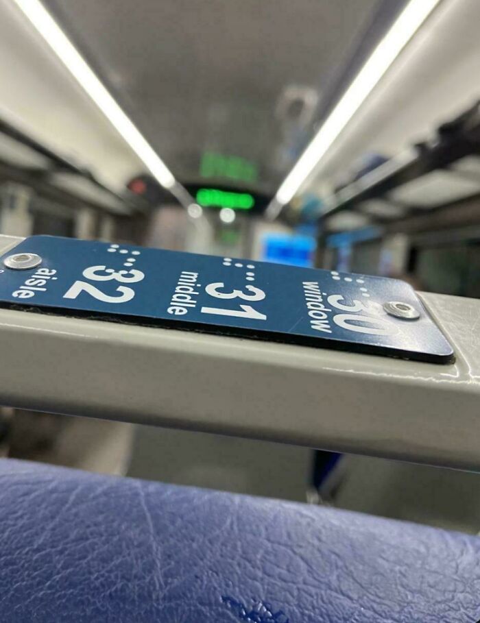 Seat number sign inside a bus incorrectly installed upside down, showcasing a perfectly preventable fail.