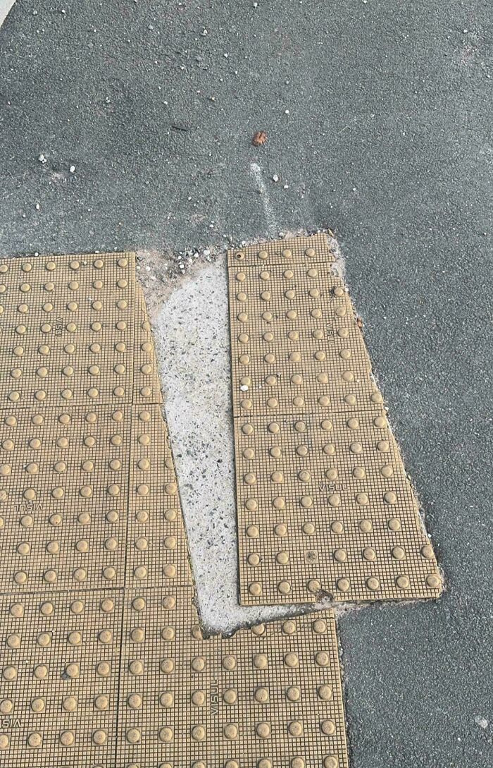Sidewalk tactile paving installed with a large gap, showing a perfectly preventable fail in construction work.