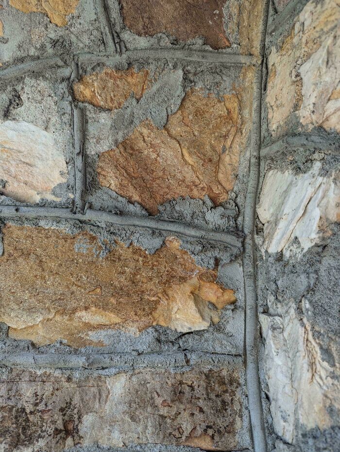Stone wall where objects seamlessly merge into the background, showing various textures and shades of brown and gray.