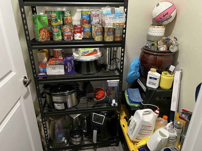 Pantry shelves fully stocked with cans and appliances seamlessly merged into the background of a cluttered storage room.