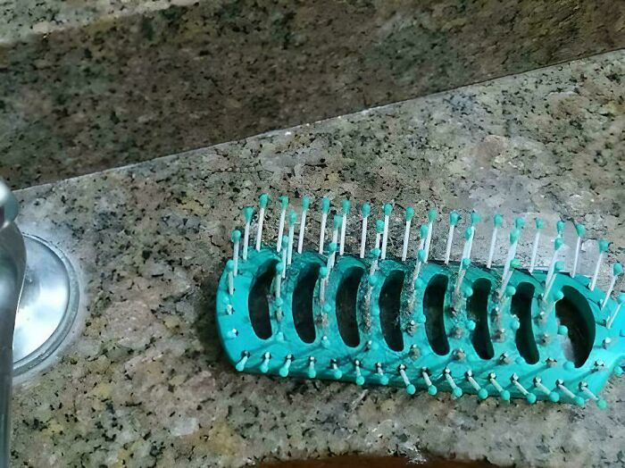 A hairbrush seamlessly merges into the granite countertop background, camouflaging itself.