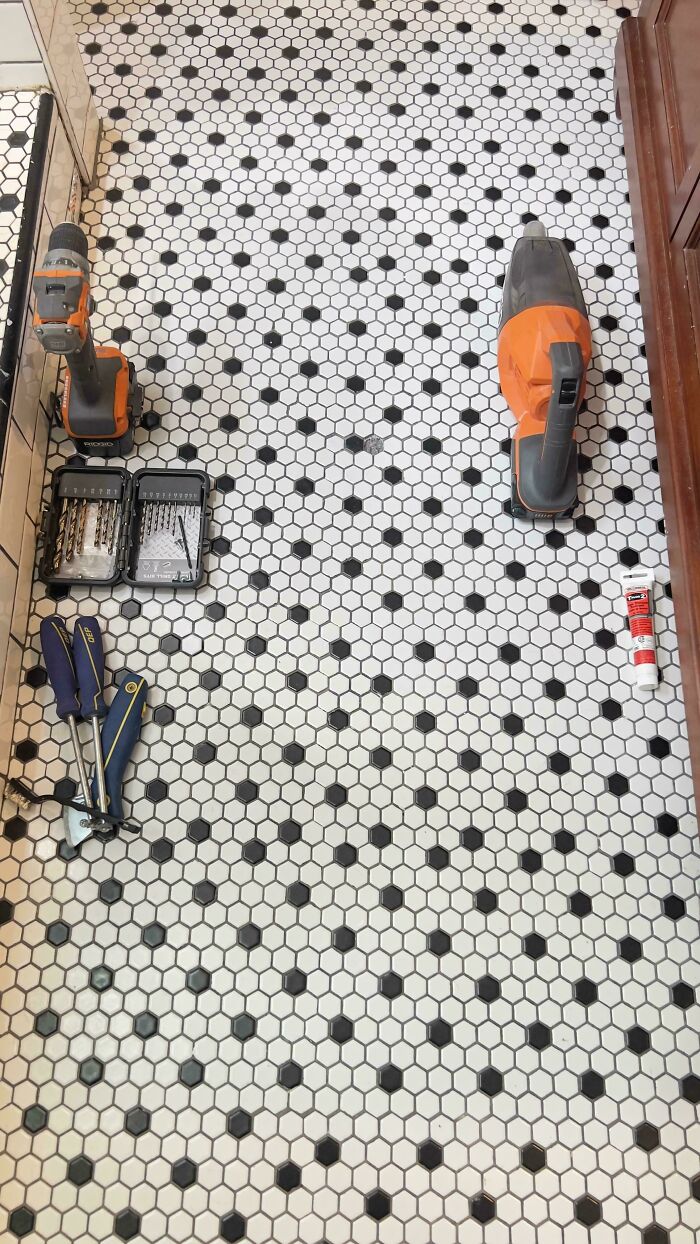 Tools blending into a patterned tile floor, seamlessly merged into the background, highlighting a clever and unexpected illusion.