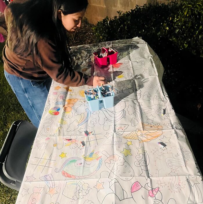 Child coloring on a large activity table with markers, demonstrating fun ways to keep kids entertained indoors.
