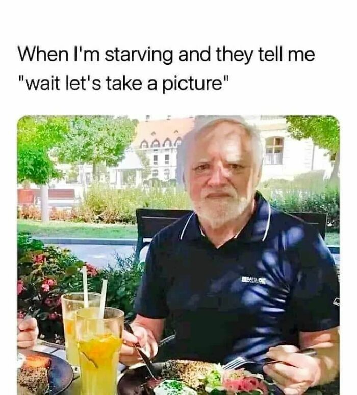 Man sitting at outdoor table with food and drinks, looking frustrated, relatable memes humor about starving and taking pictures.