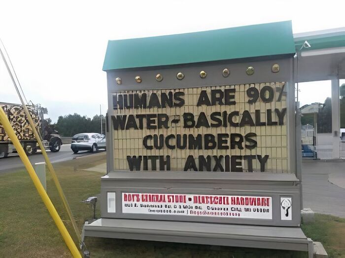 Outdoor sign humorously stating humans are 90% water, combining science and humor in a meme-style joke format.