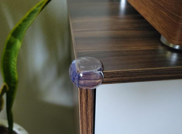Clear corner protector on a wooden table edge, demonstrating a genius parenting hack for child safety this fall season.