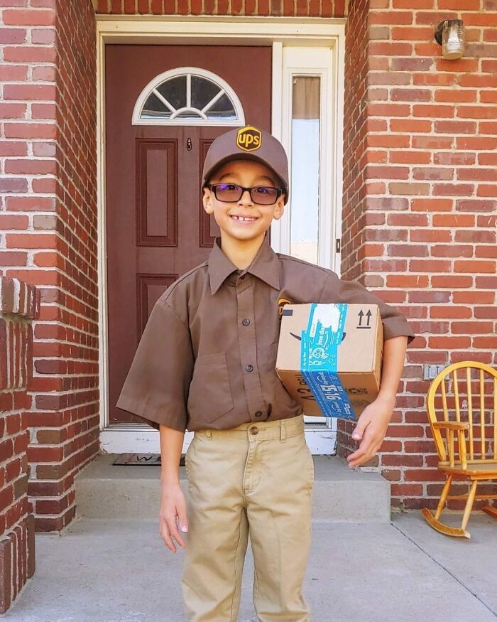 Child dressed in a UPS delivery costume holding a package, one of the kids' Halloween costume ideas that worked like magic.