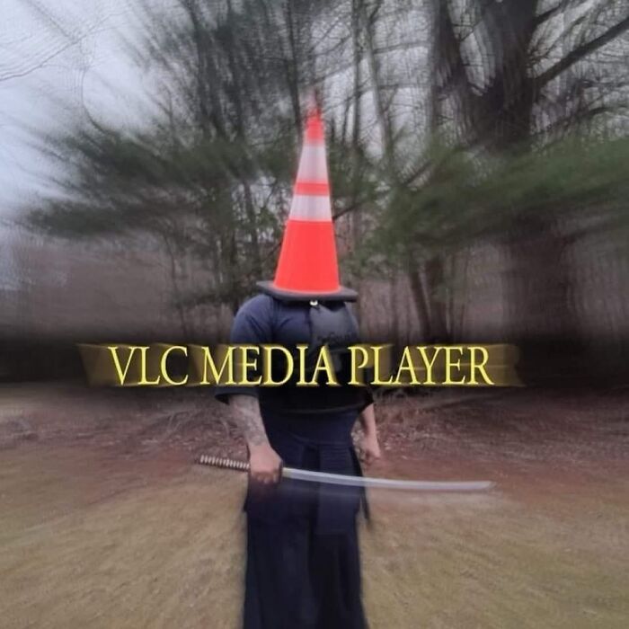 Person outdoors wearing a traffic cone on their head, holding a sword, with text "VLC Media Player" overlayed.