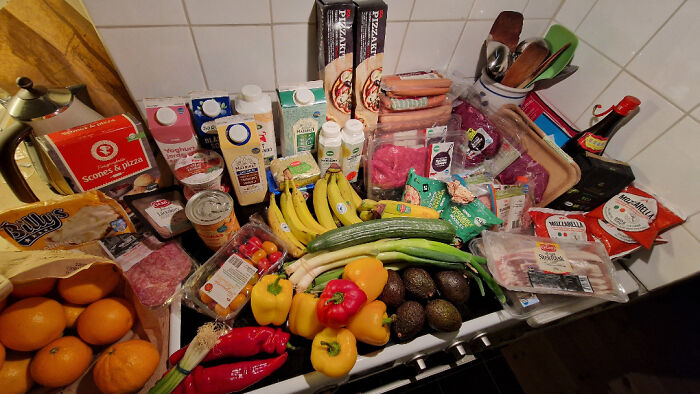 Collection of groceries found while dumpster diving, featuring fresh produce, packaged goods, and beverages.
