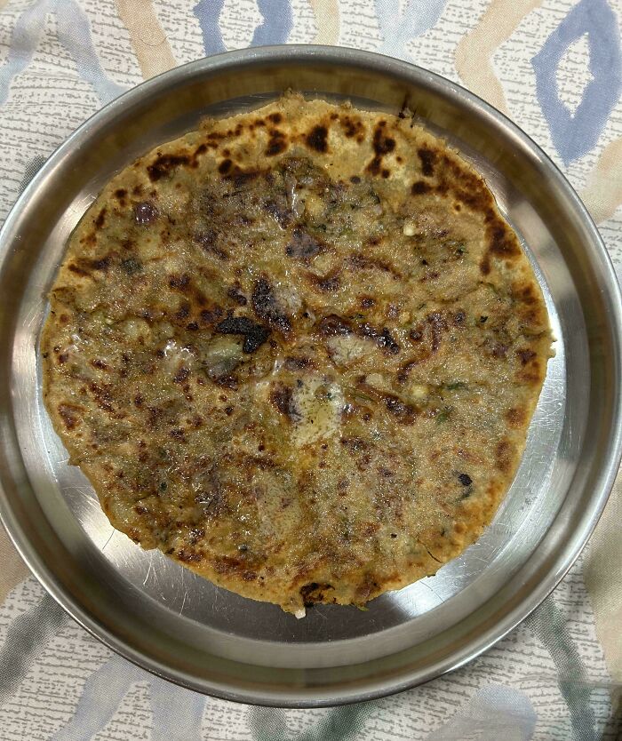 Deliciously complied extra-stuffed paratha on a metal plate.