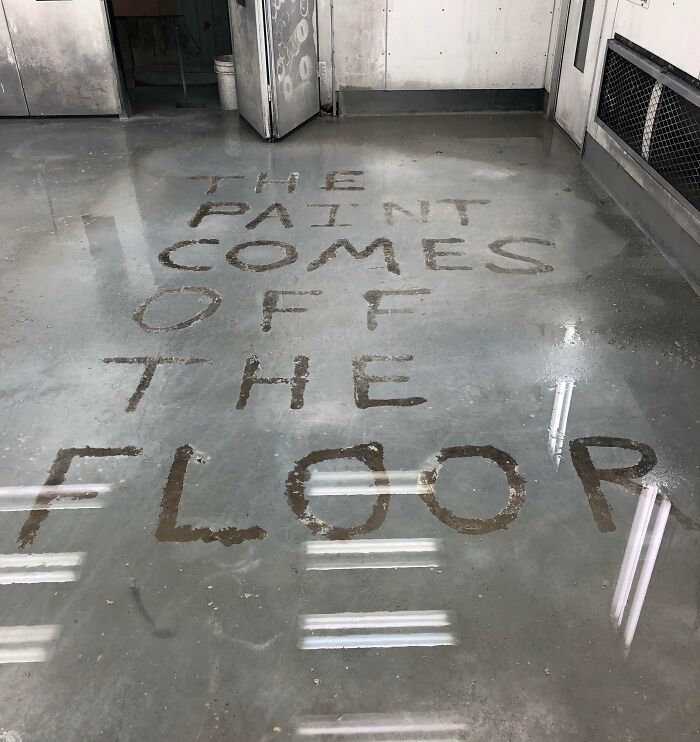 Clean floor with power washed text reading "THE PAINT COMES OFF THE FLOOR," showcasing satisfying cleaning results.