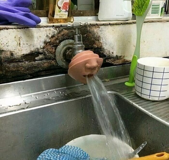Water flowing from a sink tap with a bizarre face-shaped attachment, capturing a dark, hilarious reality twist.