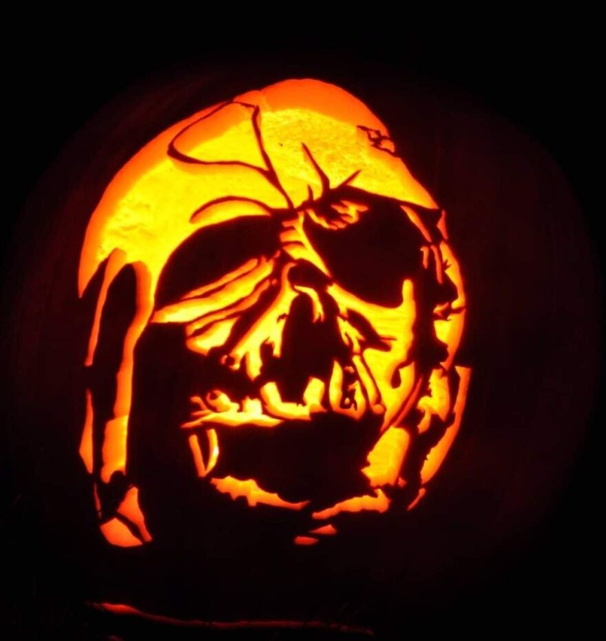 Intricately carved pumpkin glowing in the dark showcasing spooky and quirky pumpkin carvings creativity and charm.