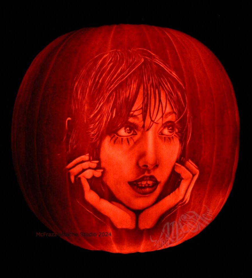 Intricately carved pumpkin displaying a detailed, spooky, and charming face with expressive eyes and hands.