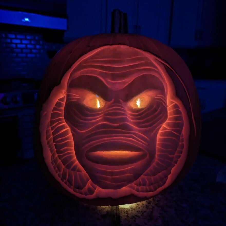 Intricately carved pumpkin featuring a glowing, spooky face with detailed lines, showcasing creative pumpkin carvings.