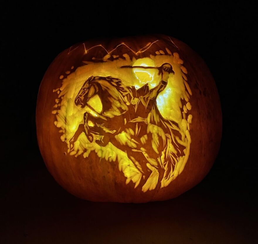 Intricate pumpkin carving of a headless horseman on horseback illuminated from within, showcasing spooky pumpkin carvings.