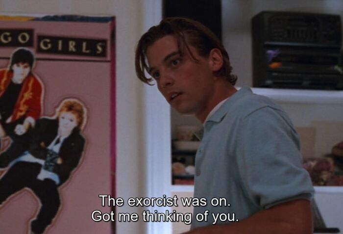 '90s teen in room with a band poster, saying, "The exorcist was on. Got me thinking of you."