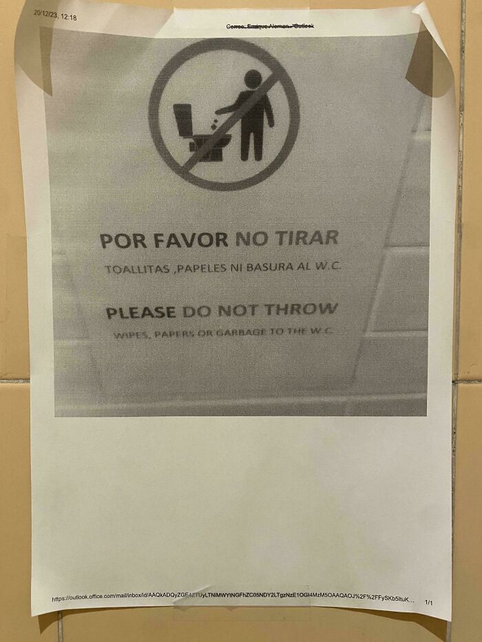 Printed sign taped on a wall showing a preventable fail warning in Spanish and English about not throwing wipes or paper in the toilet.