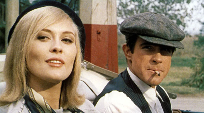 Iconic duos in a vintage setting, woman with blonde hair and man in cap smoking, evoking a classic era.