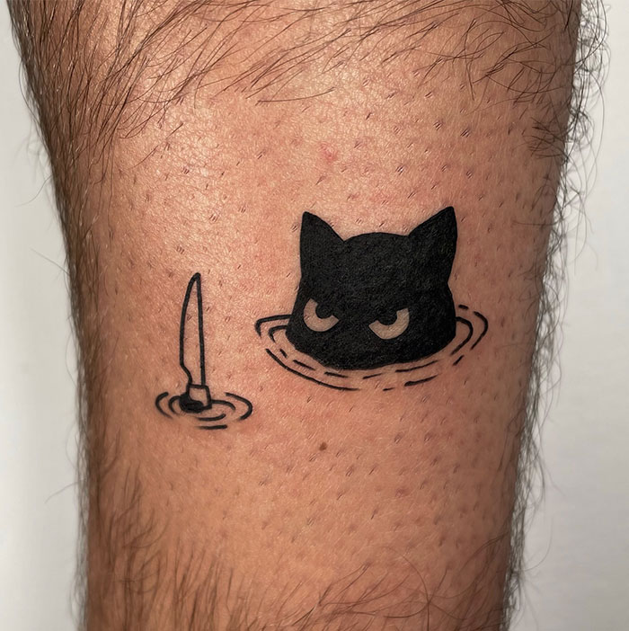 A minimalist tattoo design featuring a black cat with narrowed eyes emerging from water and a knife creating ripples. Tattoo ideas for men looking for a playful and edgy small tattoo.