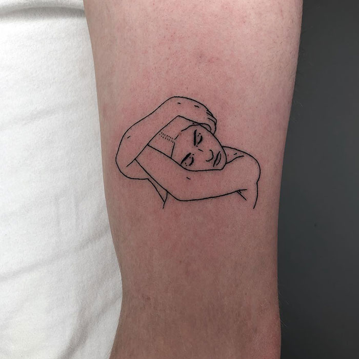 Minimalist line tattoo of a pensive figure resting their head on their arms. Tattoo ideas for men seeking a simple and introspective design that conveys calm and contemplation.