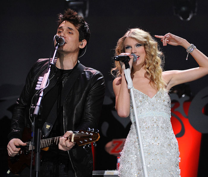 Taylor Swift in a white dress performing on stage with John Mayer playing guitar in a black jacket. How tall is Taylor Swift?