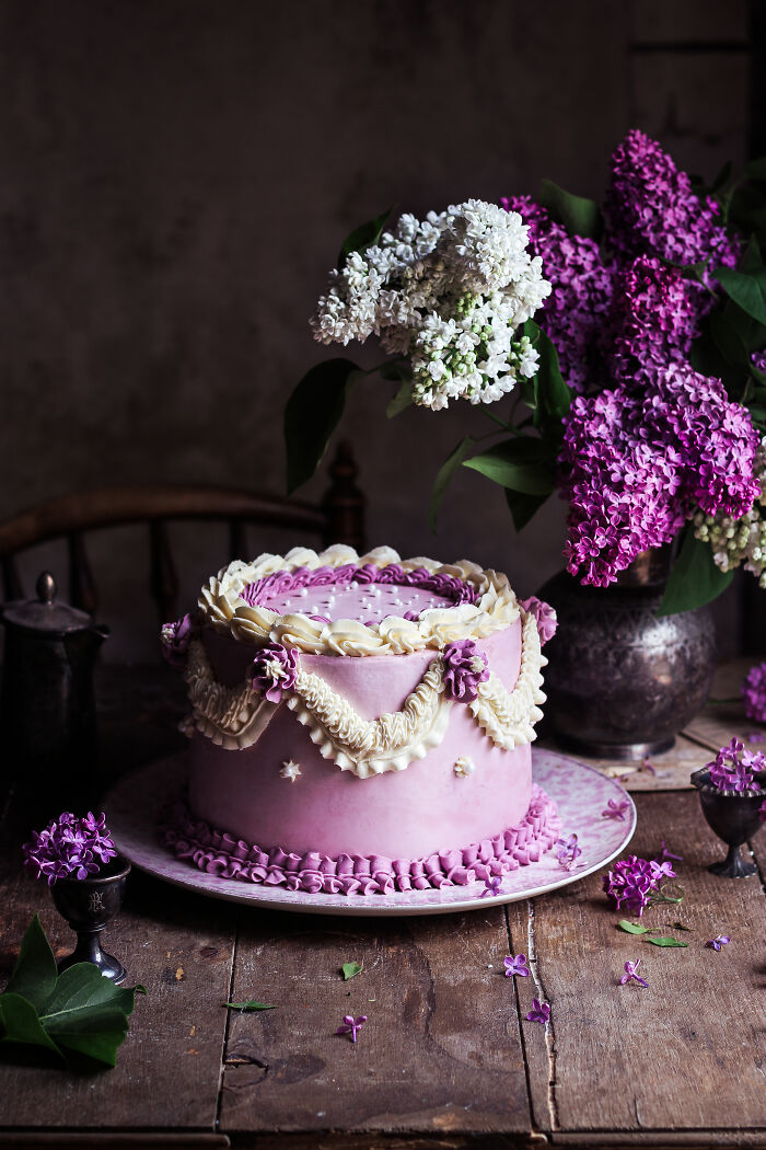 Elegant purple cake on rustic table, celebrating National Cake Day with Tiptree Cake Awards.