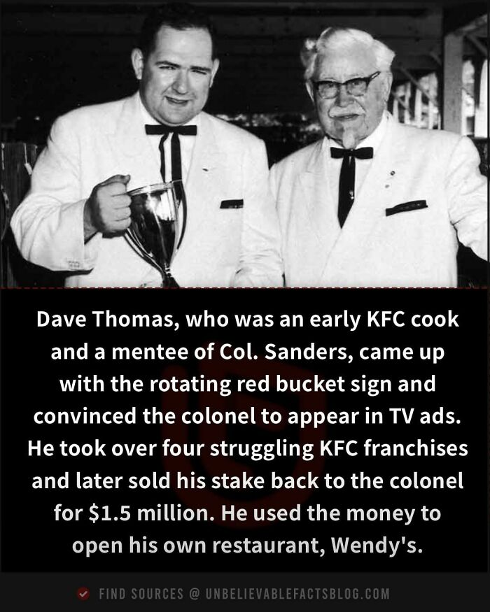 Two men in suits holding a trophy, associated with an unbelievable fact about KFC and Wendy's.