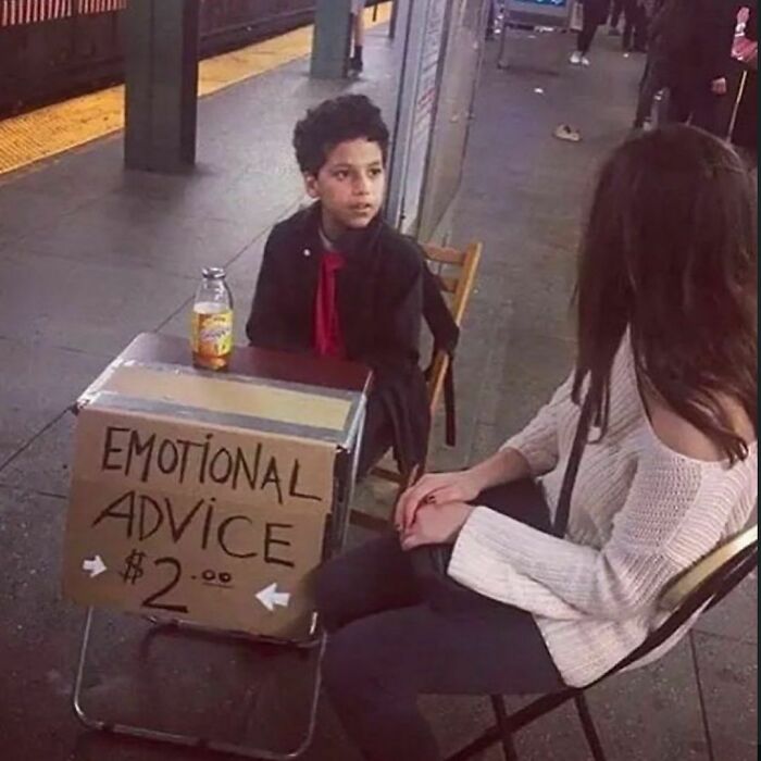 Young boy sitting at a street corner offering emotional advice for $2 in a random photo to brighten your day.