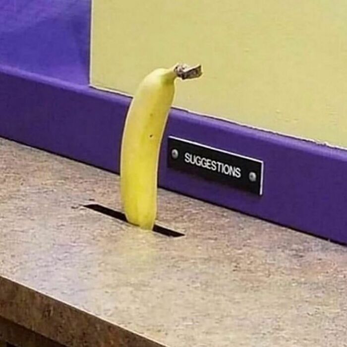 Banana inserted in a suggestion box slot, showcasing a bizarre twist of reality in a humorous setting.