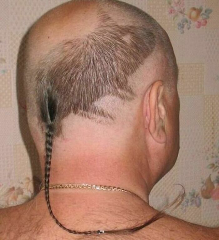 Man with a bizarre haircut featuring a small braided tail, showcasing a dark and hilarious twist in reality captured in a strange pic.