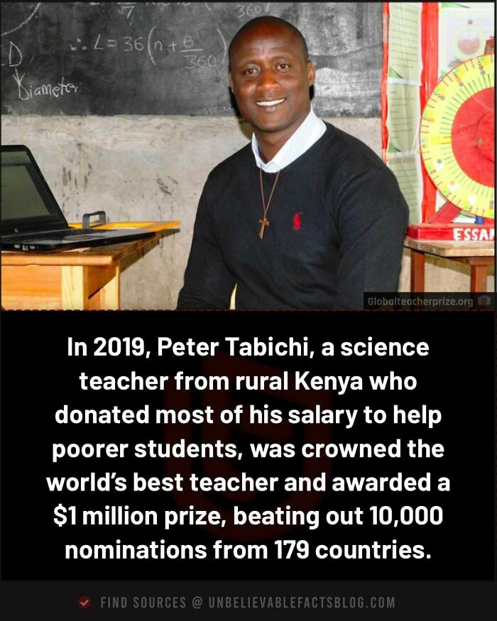 Man seated in classroom with laptop, chalkboard background; notable achievement in education recognition.
