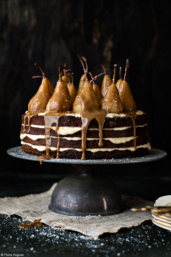 Chocolate pear cake with caramel drizzle on a stand, highlighting Tiptree Cake Awards celebration.