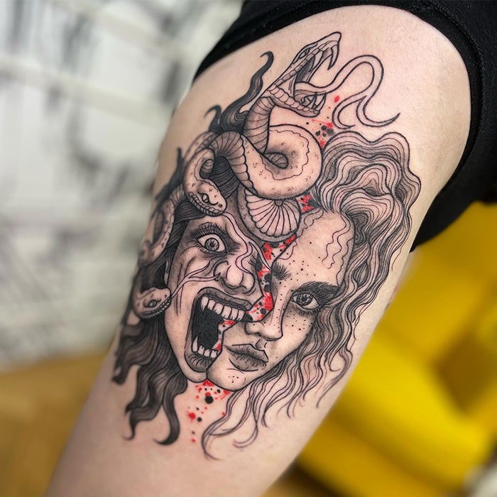 Medusa tattoo with split face design, calm and screaming, entwined with snakes, accented by red splashes.