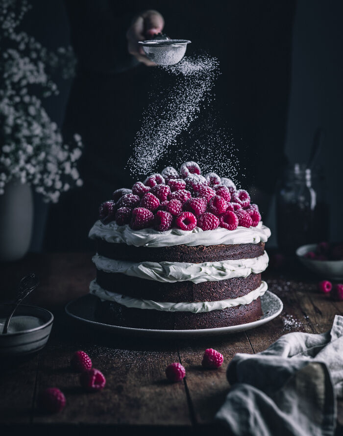 Raspberry layered cake with powdered sugar, celebrating National Cake Day with Tiptree Cake Awards.