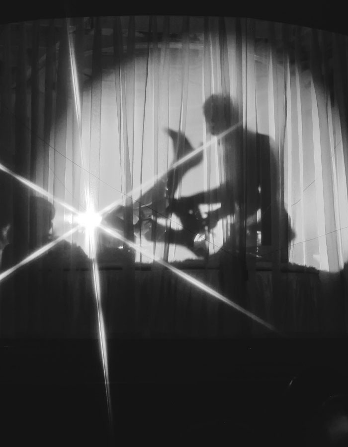 Shadow of person behind curtains, dramatic stage scene, evokes strong reactions.